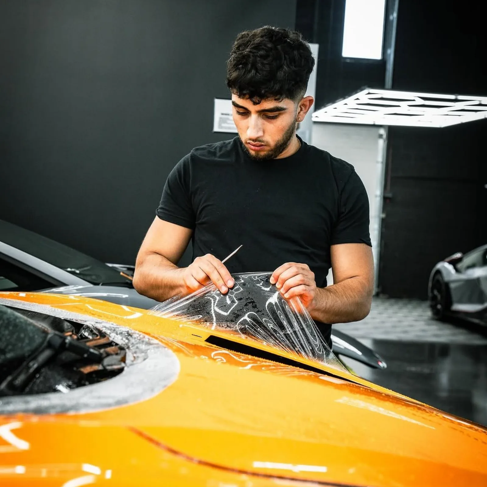 Wares working a panel by hand on a customer's car